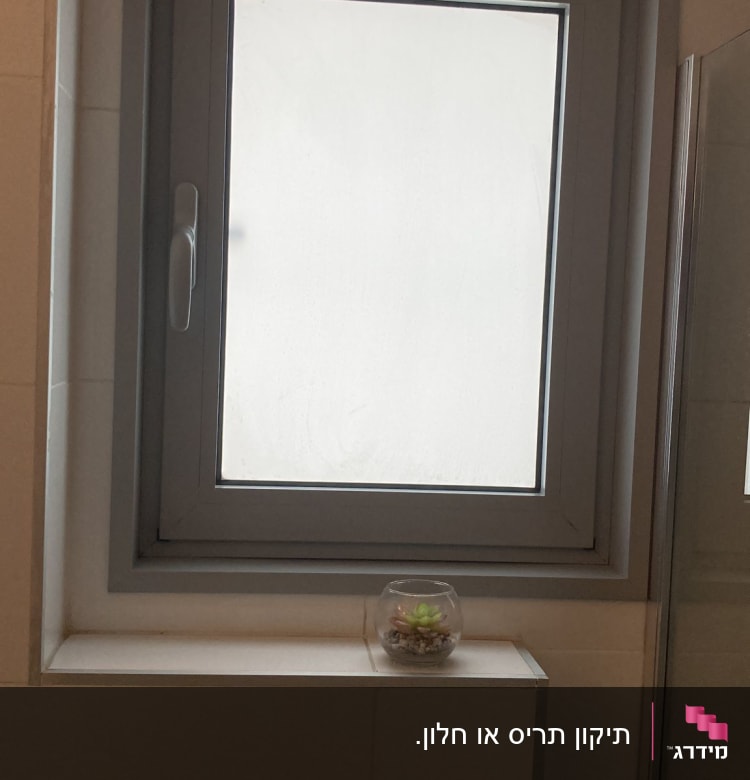 חלון עם תריסים סגורים בחדר אמבטיה